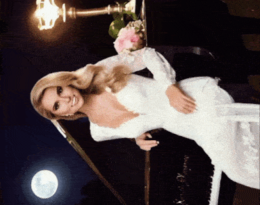a woman in a white dress sitting on a piano