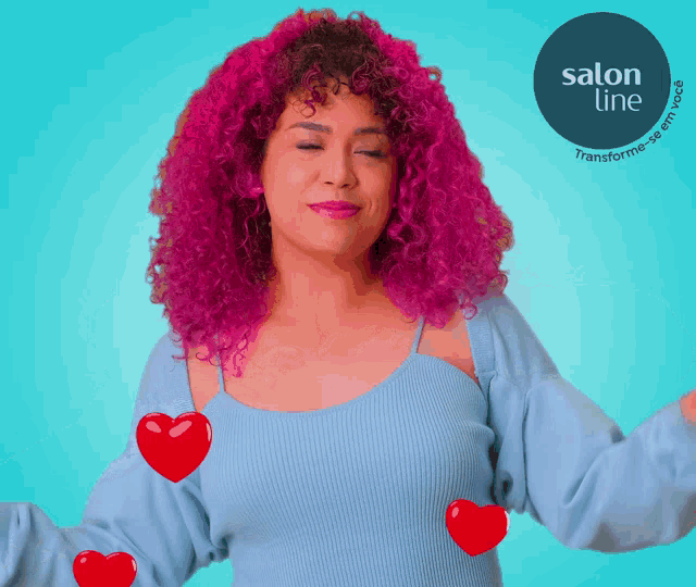 a woman with pink hair and red hearts around her shoulders is wearing a blue sweater from salon line