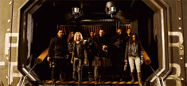 a group of people are standing in front of a door that has the letter f on it