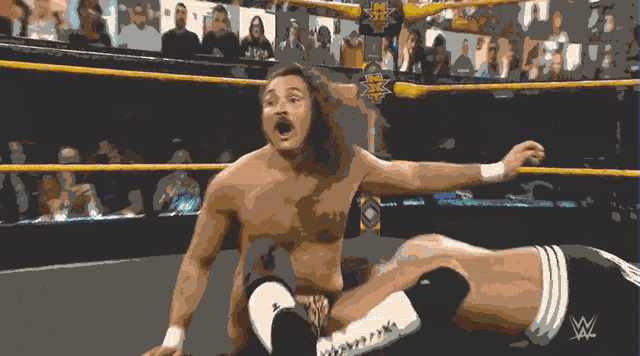 a man in a wrestling ring with the w logo