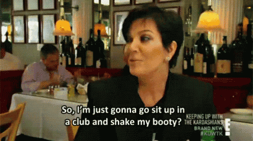 a woman is sitting at a table in a restaurant talking to a man