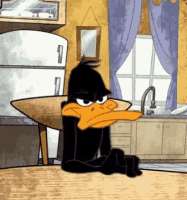 a cartoon character is sitting at a table with his arms crossed in a kitchen .