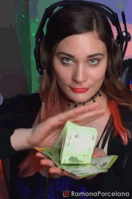 a woman wearing headphones is holding a stack of money with ramonaporcelana written in the corner