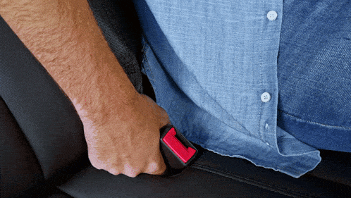 a man in a blue shirt is holding a seat belt