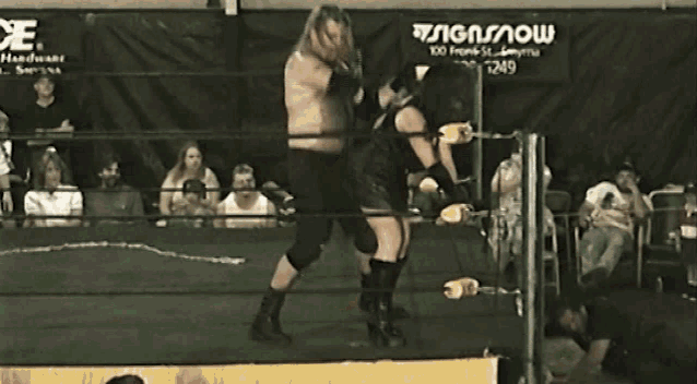 two wrestlers in a ring with a sign behind them that says ' snow '