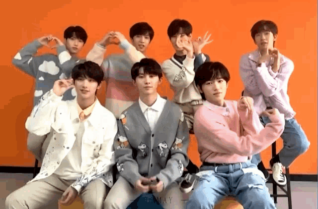 a group of young men are posing for a picture with their hands in the shape of hearts