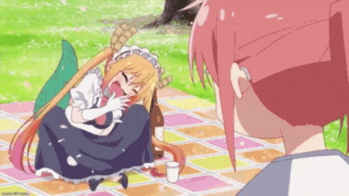 a girl with a dragon tail is sitting on a picnic blanket with a bottle of beer .
