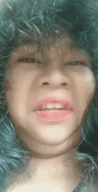 a close up of a person 's face with a furry hat on