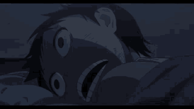 a close up of a person laying in bed with their mouth open .