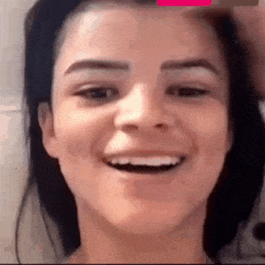 a close up of a woman 's face smiling with a man holding her hair .