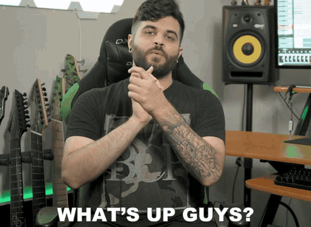 a man sitting in a chair with the words what 's up guys on the bottom