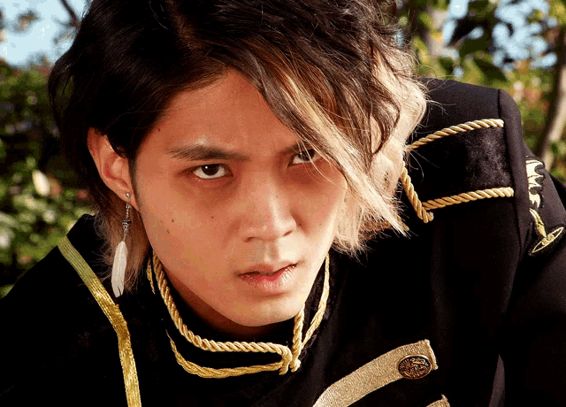 a close up of a person 's face with a black jacket with gold trim