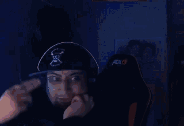 a man wearing a pirate hat and headphones is sitting in a chair and giving a thumbs up .
