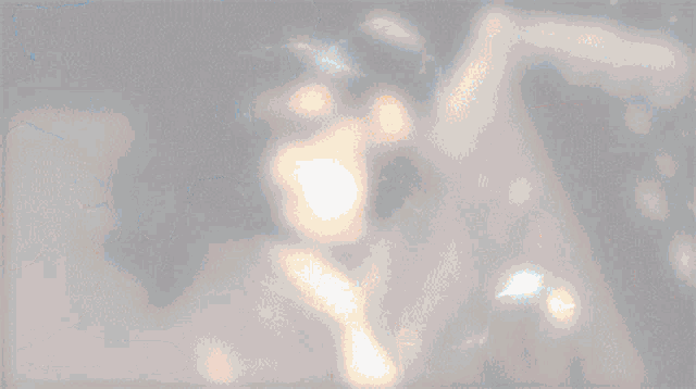a blurred image of a person 's face with a light coming out of it