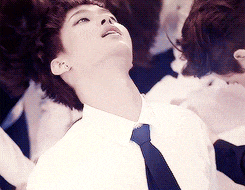 a man in a white shirt and tie looks up at something