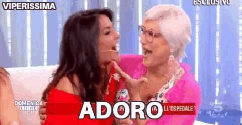 two women are sitting next to each other on a couch and one of them says adoro