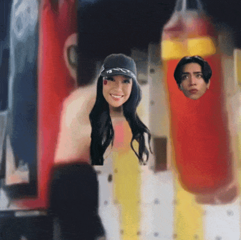 a man and a woman are standing next to a punching bag with their faces in it