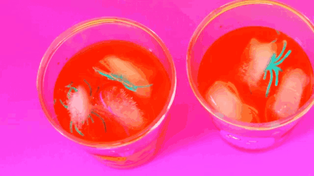 a person is putting a toy spider in a cup of jelly .
