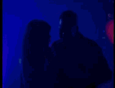 a man and a woman are kissing on a stage