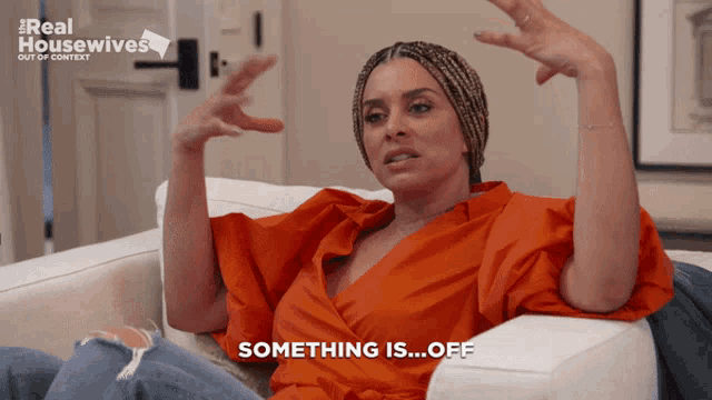 a woman sitting on a couch with her arms outstretched says something is off