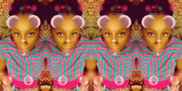 a little girl wearing a pink and green striped shirt with bear ears on her face ..