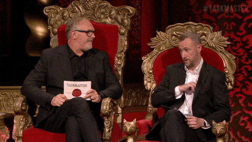 two men sit on a throne with a card that says taskmaster on it