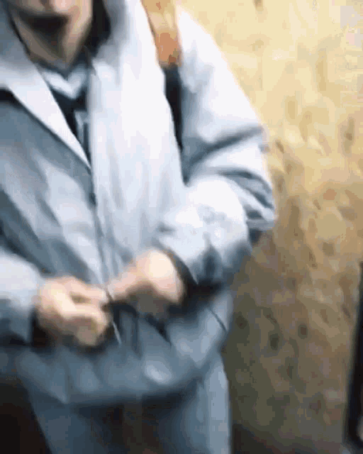 a man wearing a jacket and tie is standing in an elevator .