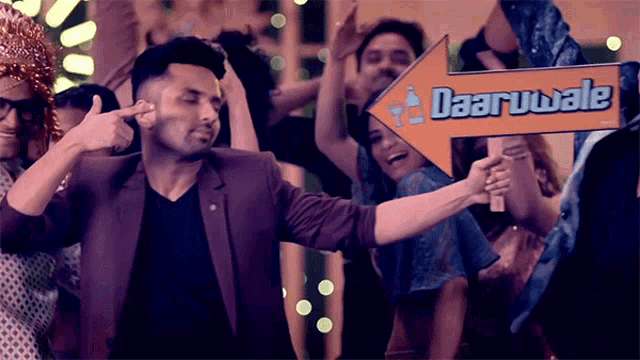 a group of people are dancing and holding a sign that says daaruwale