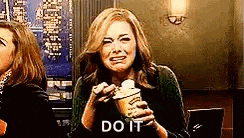 a woman is eating a sandwich and crying while holding a bottle of soda .