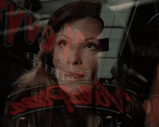 a woman is looking through a window at a sign that says hollywood