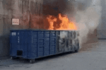 a dumpster is on fire and smoke is coming out of it ..