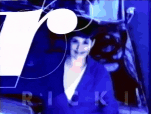 a woman in a blue suit stands in front of a blue background with the word rick on it