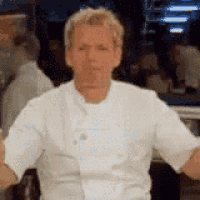 a man in a white chef 's coat is standing in front of a crowd .