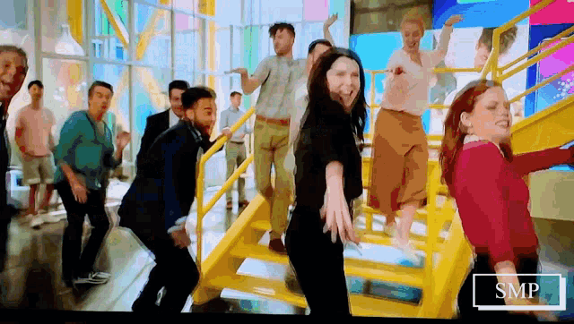 a group of people are dancing on a set of stairs with the letters smp on the bottom right