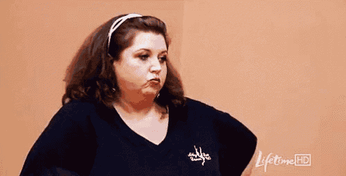 a woman is making a funny face while wearing a black shirt .