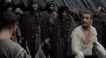a man is standing in front of a group of men .
