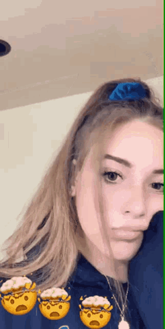 a girl wearing a blue headband and a necklace is making a funny face .