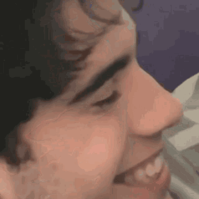 a close up of a person 's face with a purple background .