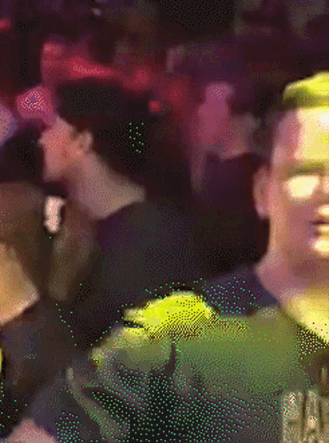 a blurry picture of a crowd of people with a man wearing a shirt that says ' a ' on the front
