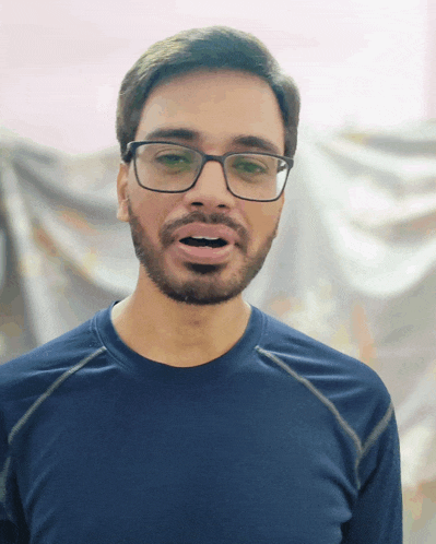 a man wearing glasses and a blue shirt is making a face