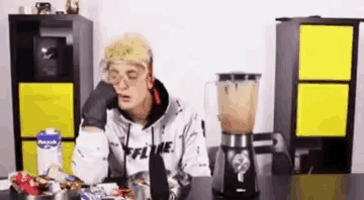 a man is sitting at a table with a blender and a blender .