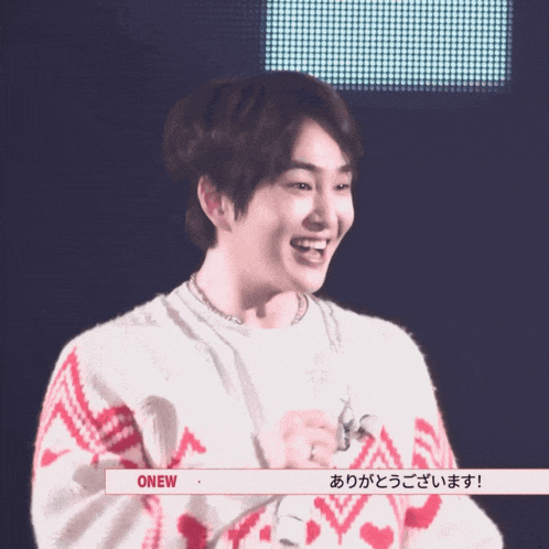 a man wearing a red and white sweater with the word onew on the bottom