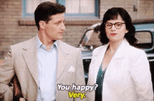a man and a woman are standing next to each other and the woman is saying `` you happy ? very '' .