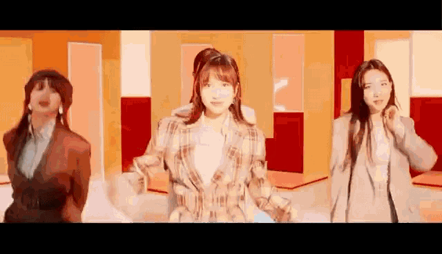 a group of women are dancing together in a room in a video .