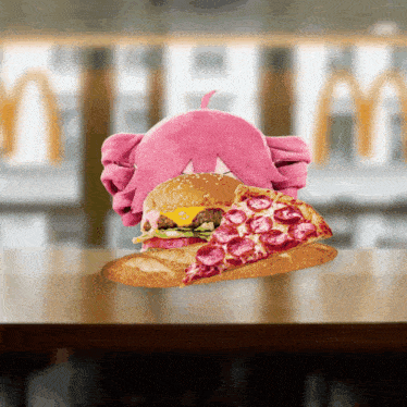 a hamburger and a slice of pepperoni pizza on a table in front of a mcdonald 's sign