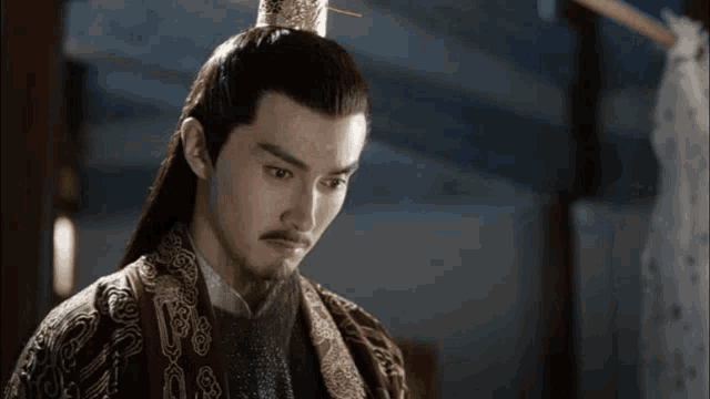 a man with long hair and a beard wearing a crown