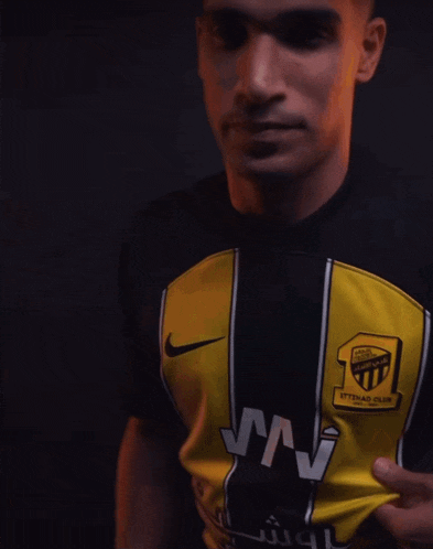 a man wearing a black and yellow shirt that says ' ross ' on it