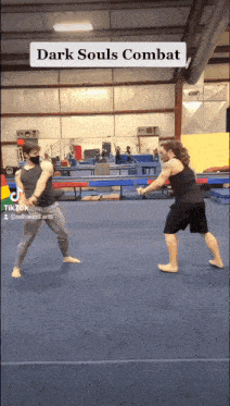 two men are practicing martial arts in a gym with the words dark souls combat at the top