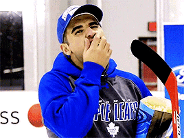 a man wearing a blue hoodie that says maple leafs