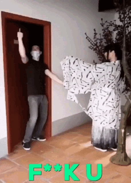 a man wearing a mask is giving the middle finger to a woman in a kimono who is standing in front of a door